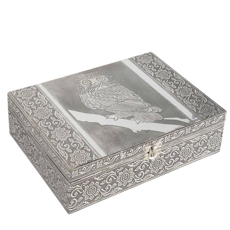 Decorative silver jewelry box with owl design on a white background