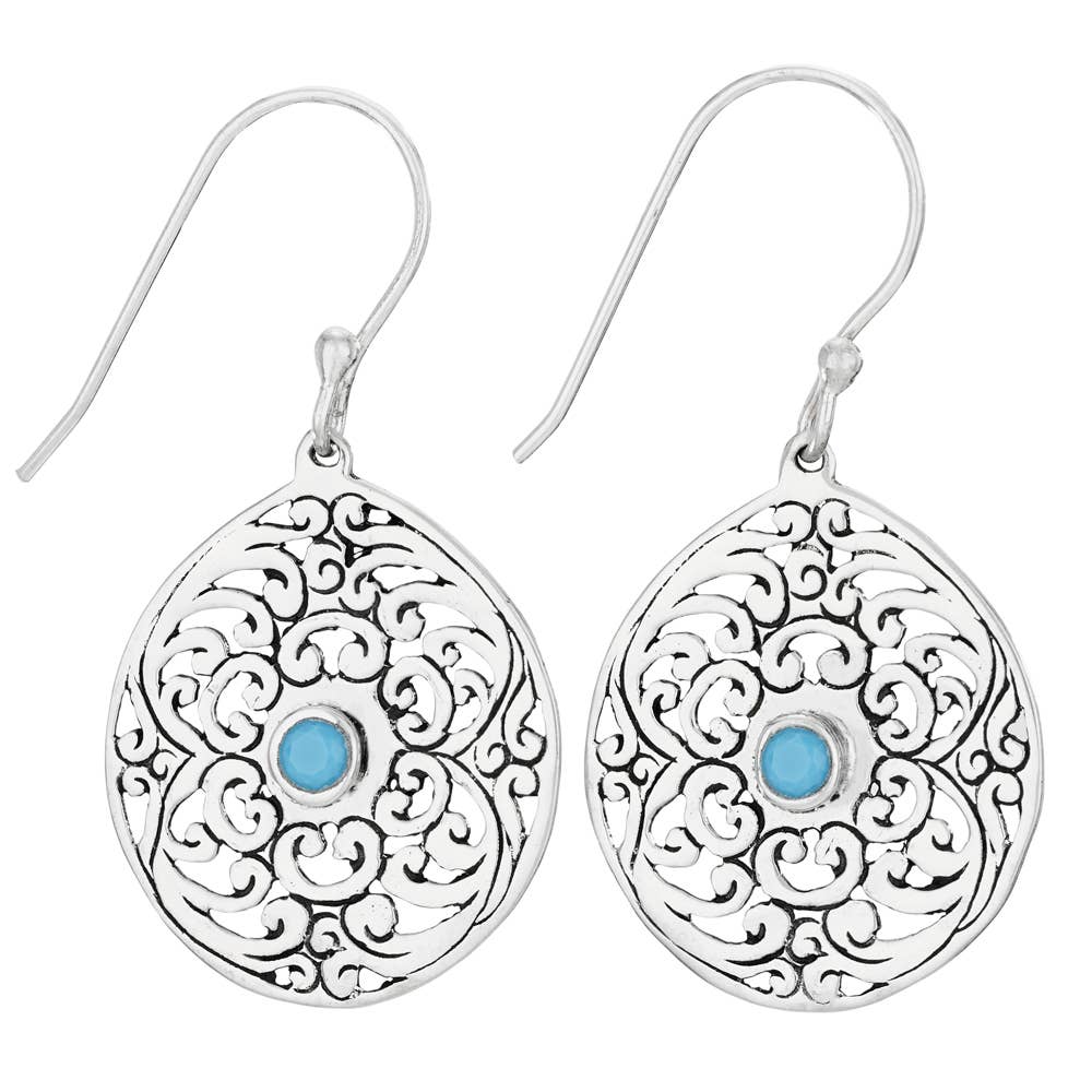 Silver earrings with intricate designs and blue gemstones on a white background