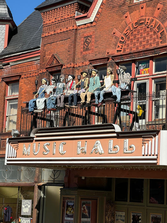 A fun group of dressed up skeletons sitting on the marquee sign of the Tarrytown Music Hall in Tarrytown, NY