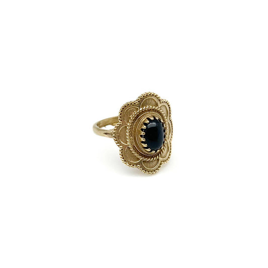 Gold-tone brass ring with a black gemstone on a white background