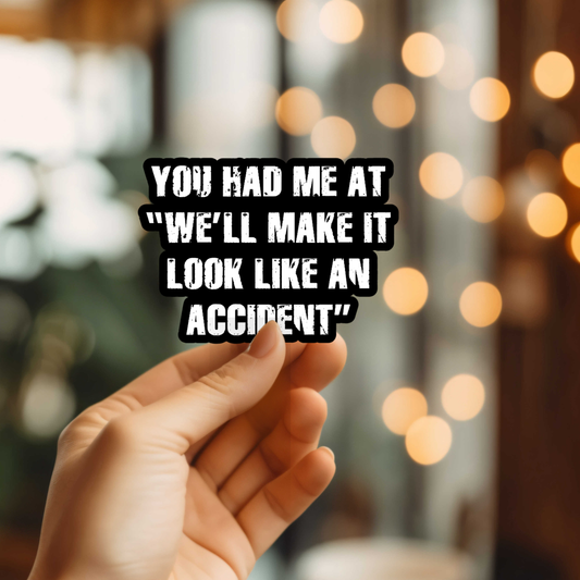Hand holding a sticker with text overlay against a blurred background with lights