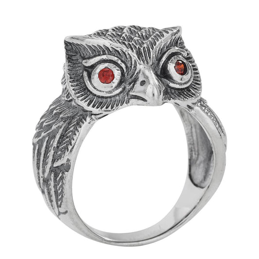 A sterling silver owl ring with detailed feather engravings and small red gemstone eyes, shown on a plain white background.