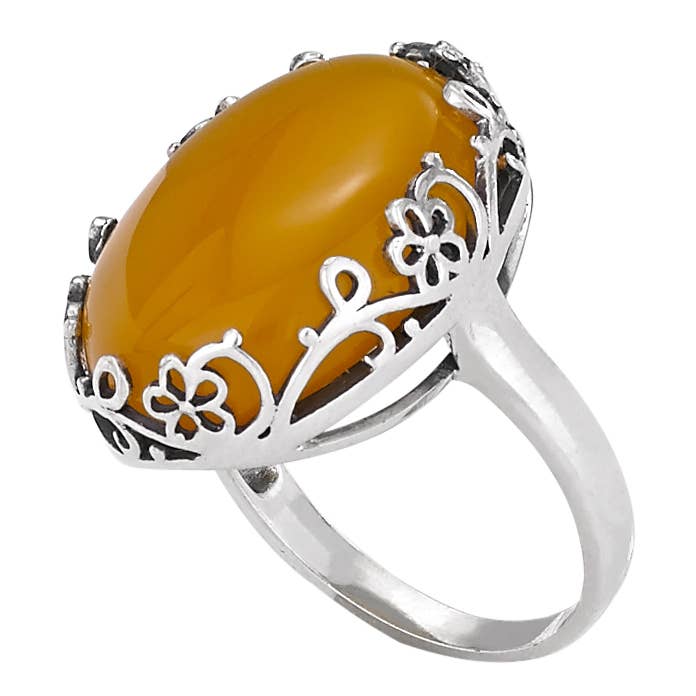 Silver ring with a large yellow gemstone on a white background