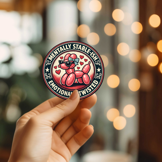 Hand holding a sticker with a cartoon balloon dog design and text against a blurred background