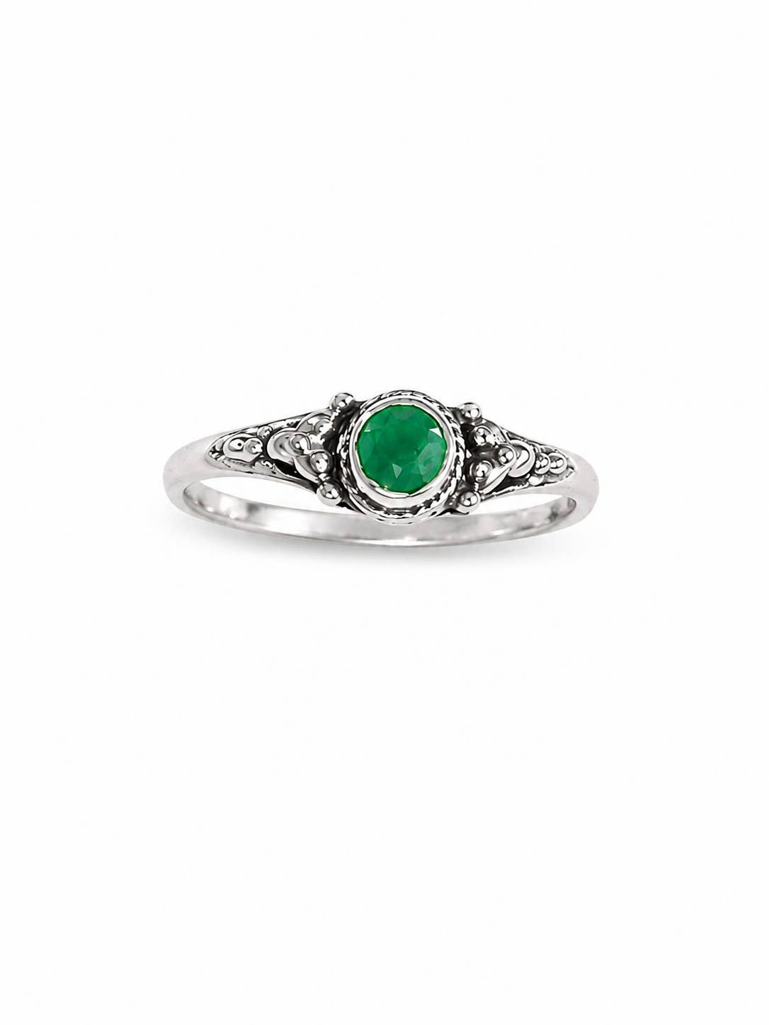 A silver ring featuring an oval-cut Emerald green gemstone in a decorative filigree setting, shown against a plain white background.