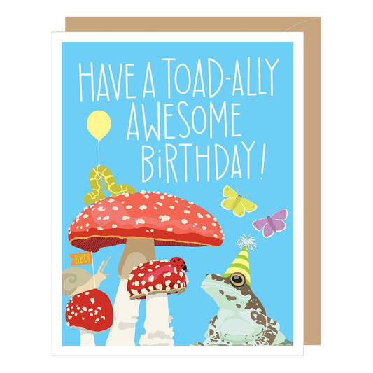 Birthday card with a frog, mushrooms, and text 'Have a toad-ally awesome birthday!' on a blue background.
