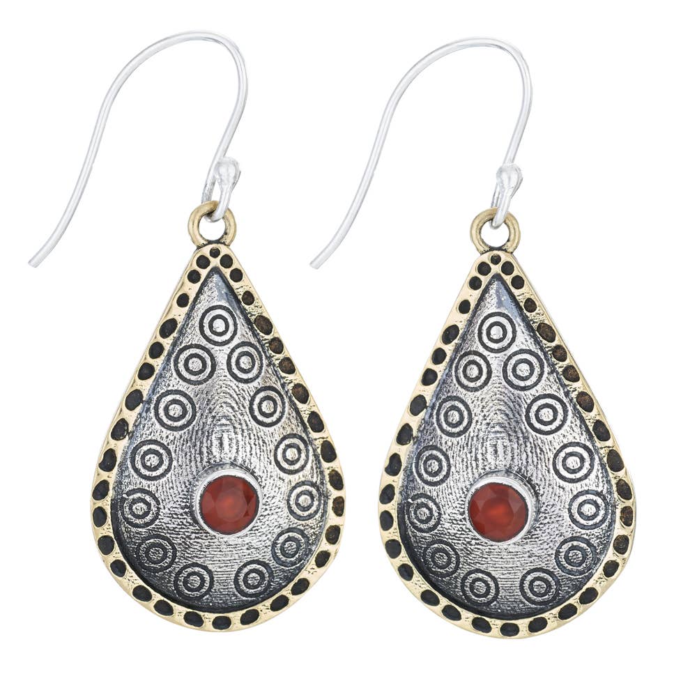 Teardrop-shaped earrings with circular patterns and red stones on a white background
