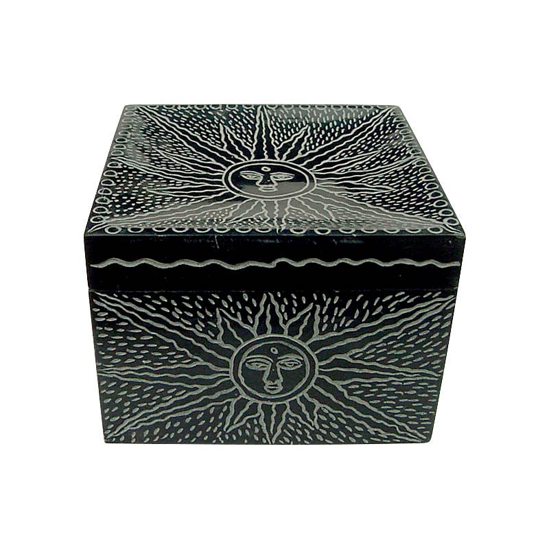Black decorative trinket box with sun and face design on a white background