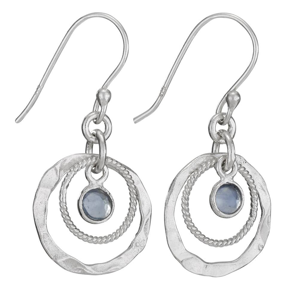 Silver earrings with circular designs and blue gemstones on a white background
