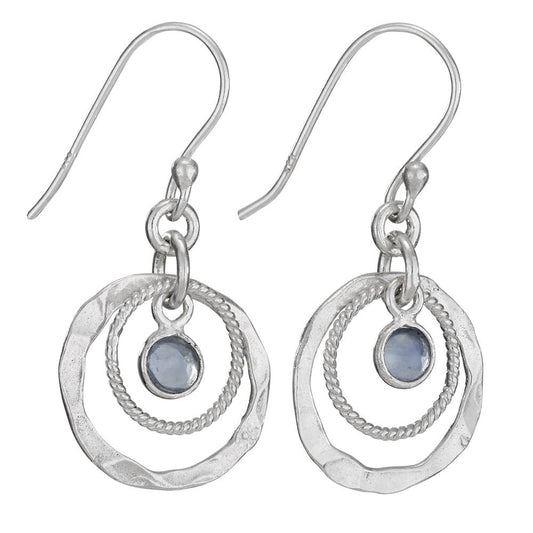 Silver earrings with circular designs and blue gemstones on a white background