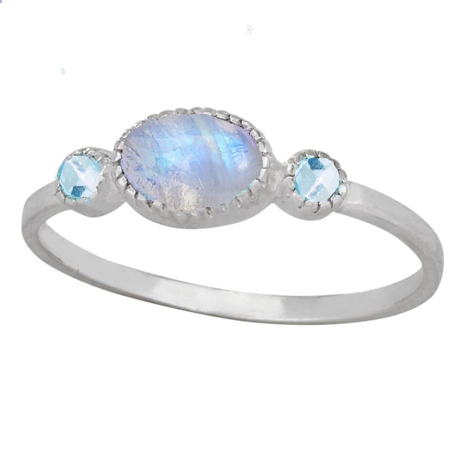 A silver ring featuring a large oval iridescent moonstone center stone and two small round light blue gemstones on either side, set in a polished silver band against a white background.