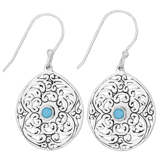 Silver earrings with intricate designs and blue gemstones on a white background