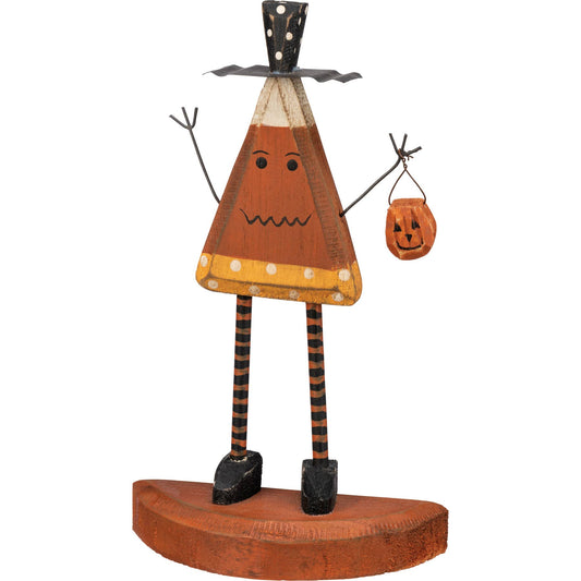 Wooden Halloween decoration with a candy corn triangular head, striped legs, and pumpkin-shaped bag on a white background.