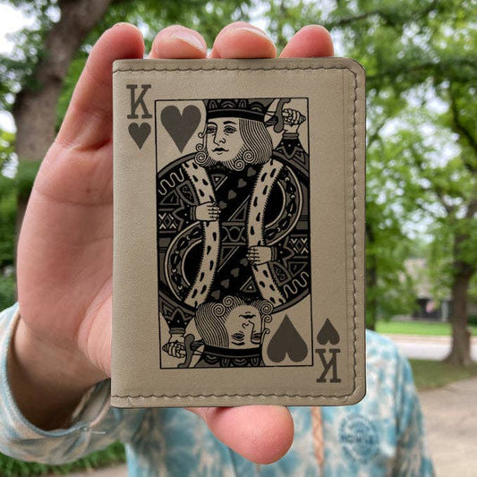 Hand holding a Wallet with a King of Hearts design against a blurred outdoor background