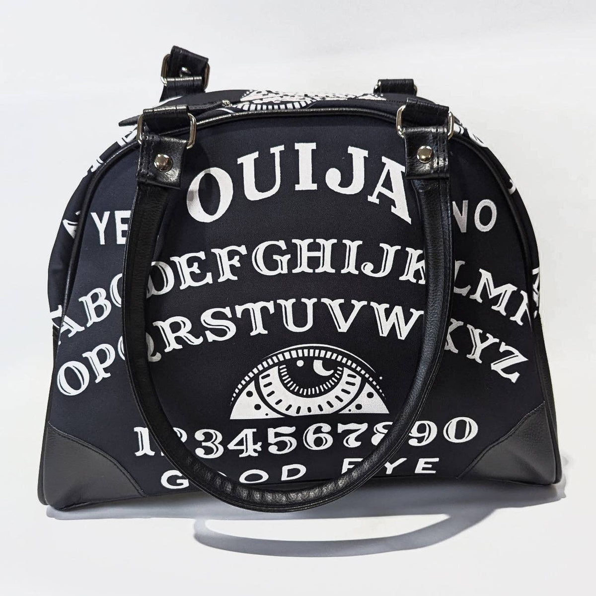 Black handbag with Ouija board design on a white background