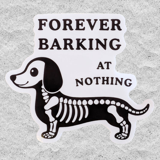 A die-cut vinyl sticker featuring a black and white dachshund skeleton with the text 'FOREVER BARKING AT NOTHING' in bold black lettering, displayed on a textured gray background.