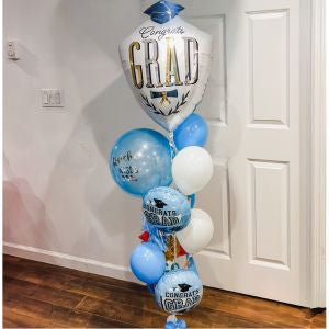 Graduation-themed balloon bouquet with 'Congrats Grad' text, in a room.