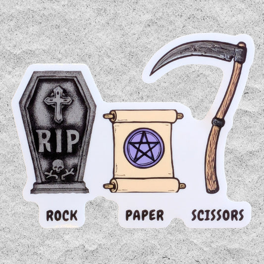 Illustrated die-cut sticker on a light gray textured background: a tombstone reading RIP with a cross and skull, a parchment scroll with a purple pentagram, and a scythe. Below the stickers, the words ROCK, PAPER, and SCISSORS appear.