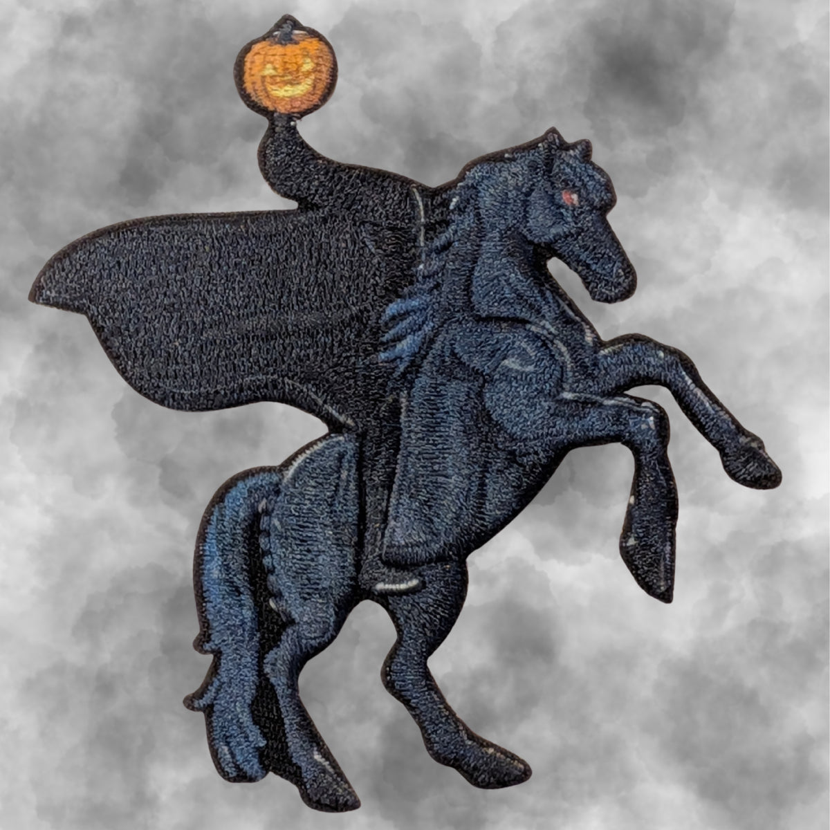 A Headless Horseman Embroidered Patch on a Spooky grey background.