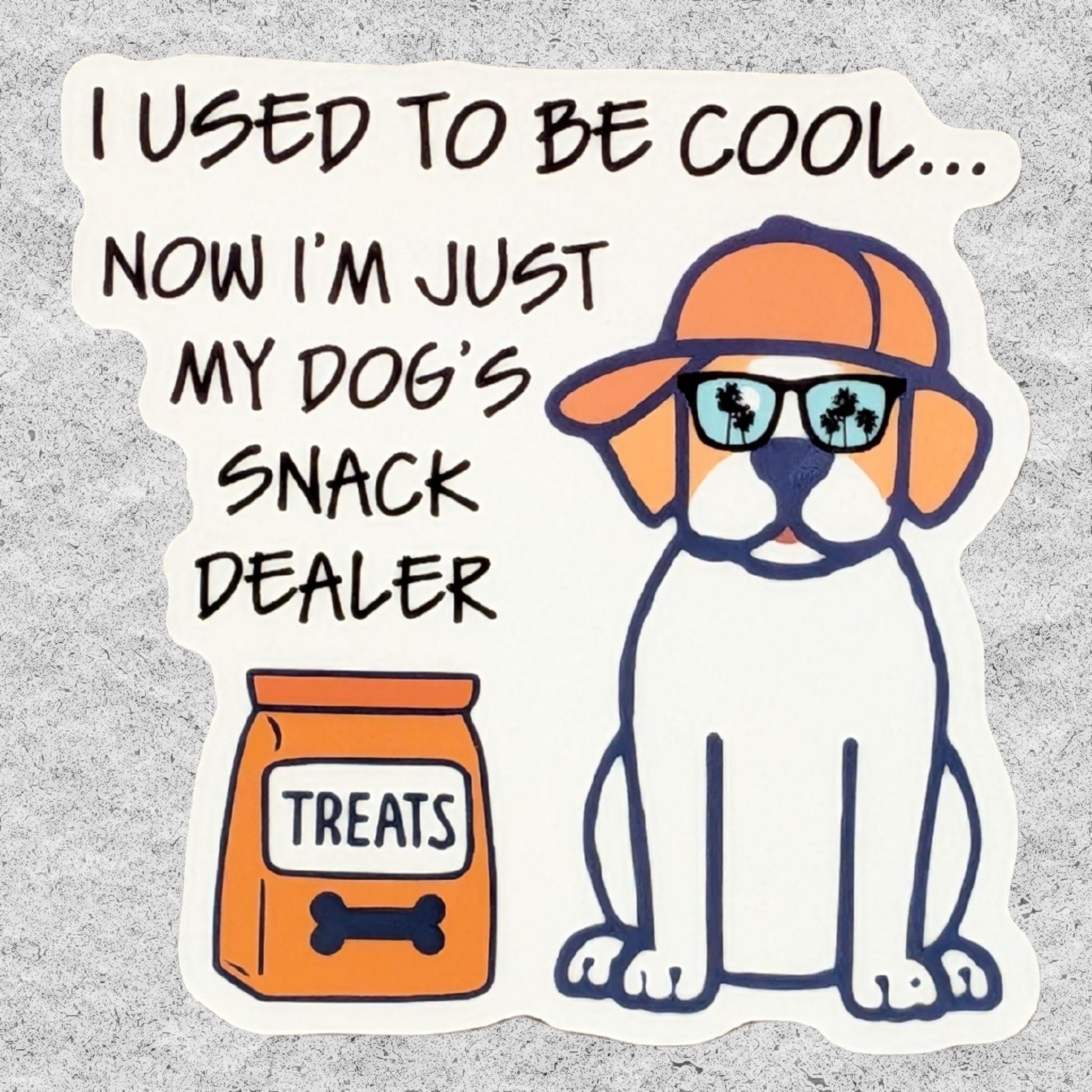 A die-cut sticker with a humorous cartoon design and the text 'Now I'm just my dog's snack dealer". The sticker features a white and tan dog wearing an orange cap and sunglasses with palm tree reflections, next to an orange bag of dog treats.