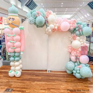 Custom Balloon Garland with pastel colors and a balloon sculpture of a toy soldier in a store setting