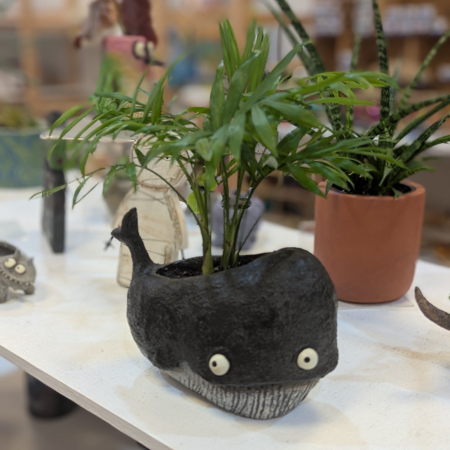 Whale planter full of potted plants
