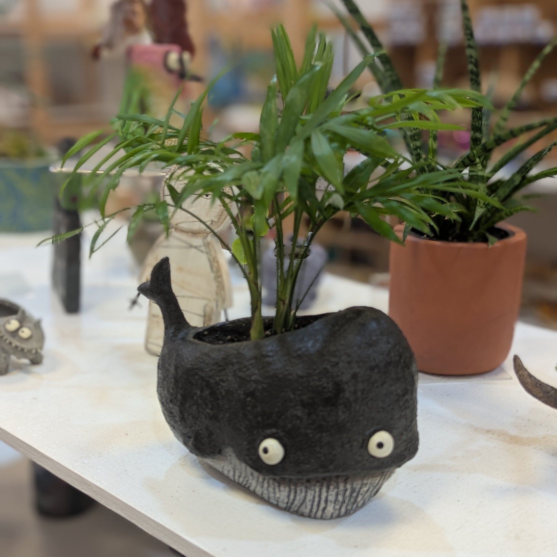 Whale planter full of potted plants