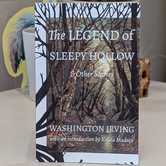 Book titled 'The Legend of Sleepy Hollow & Other Stories' by Washington Irving, and an introduction by Kristen Madsen on a surface with a blurred background.