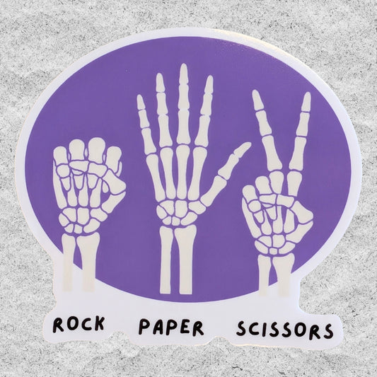 A sticker with three skeleton hands doing rock, paper, scissors on a purple background.