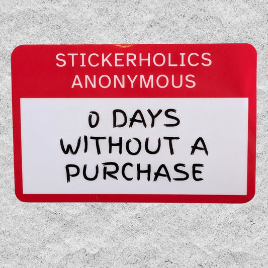 A rectangular sticker with a red header reading 'STICKERHOLICS ANONYMOUS' and a white lower section with black handwritten text that says '0 DAYS WITHOUT A PURCHASE', shown against a textured gray background.
