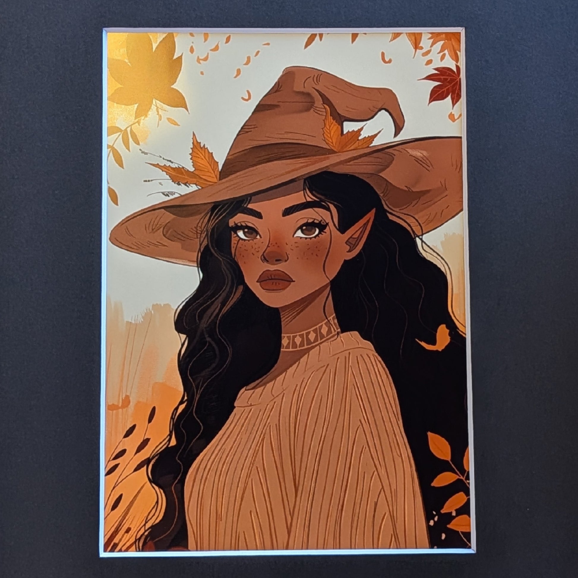 A vertical art print featuring an illustration of a witch-like woman with long dark wavy hair, pointed ears, and a brown witch hat with autumn leaves, shown against a dark gray background.