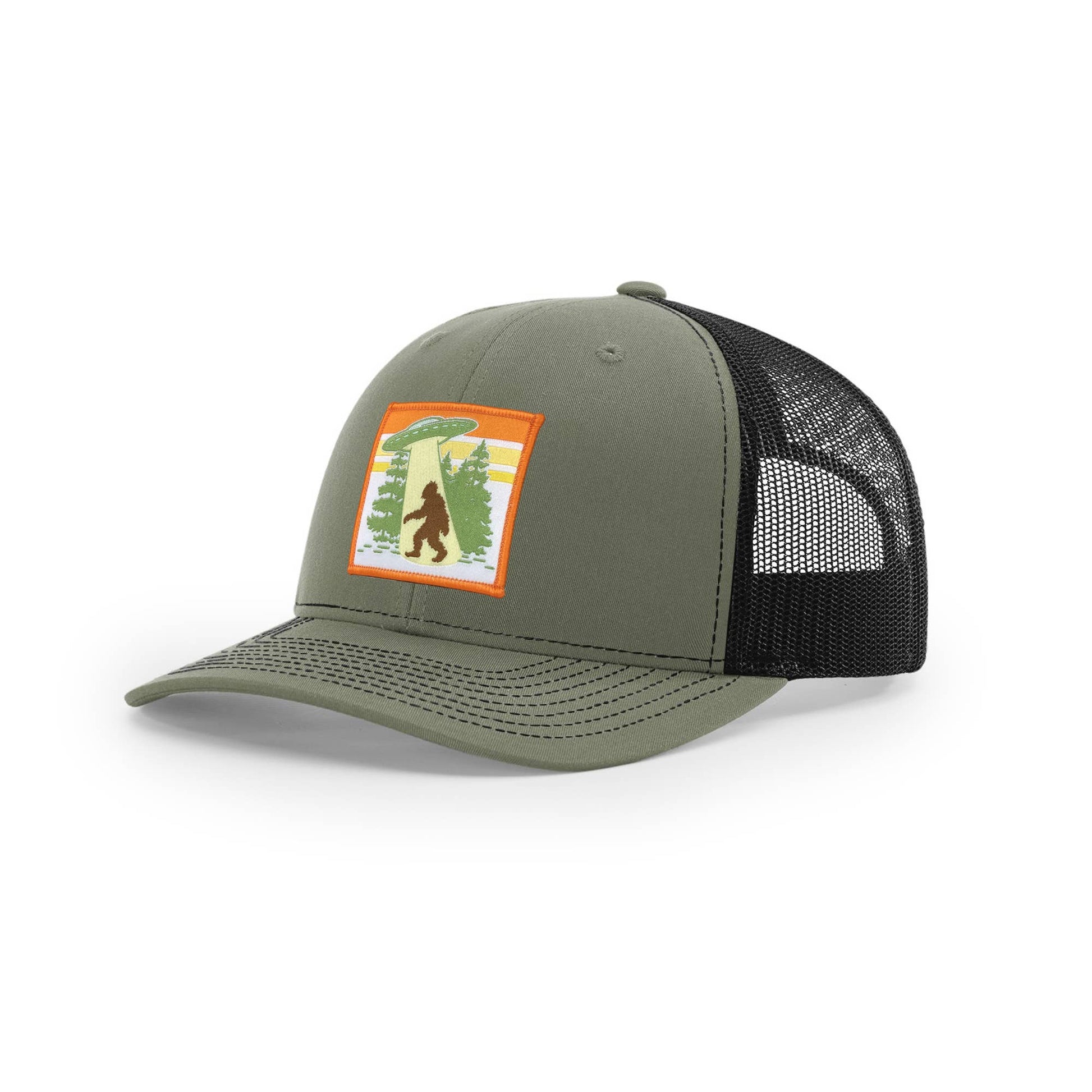 Green and black mesh cap with a patch featuring sasquatch in a forest on a white background