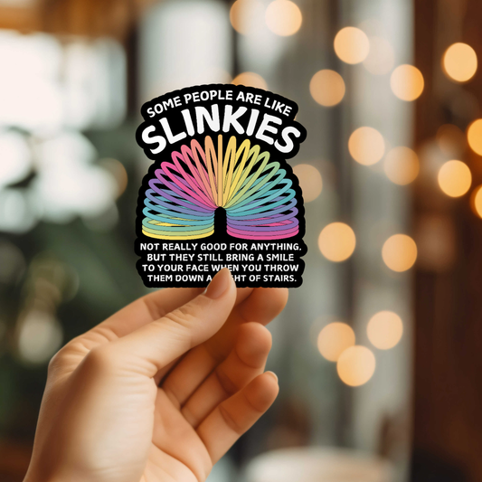 Hand holding a colorful sticker with a slinky and text against a blurred background