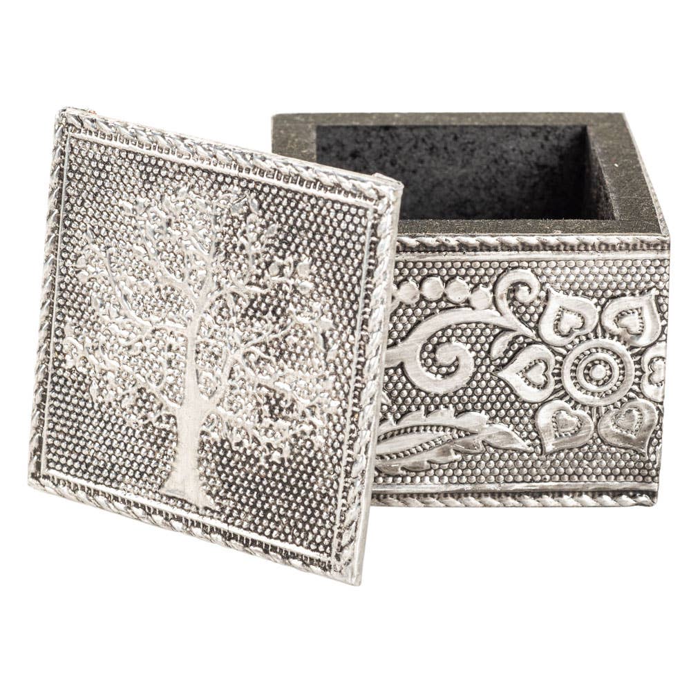Decorative silver box with intricate tree and floral designs on a white background