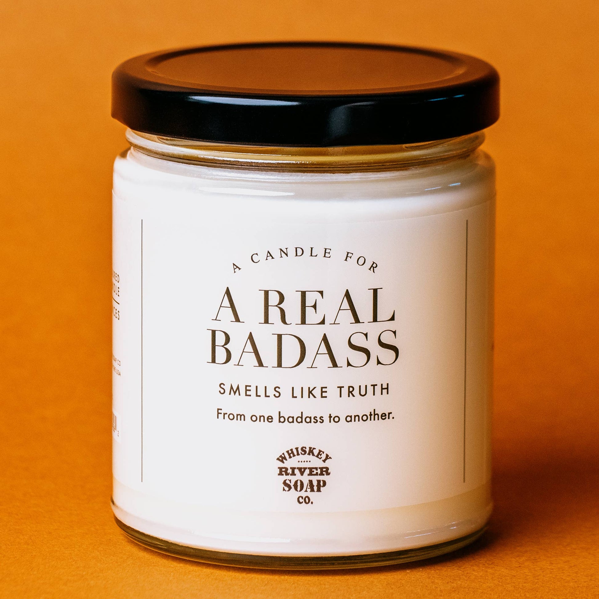 Candle jar with a label on an orange background