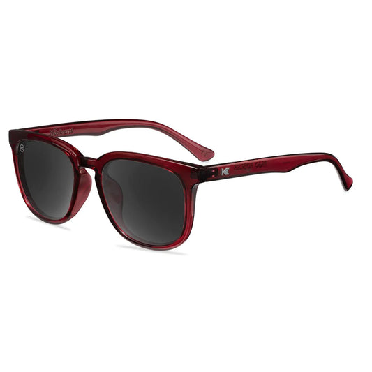 Burgundy sunglasses with dark lenses on a white background