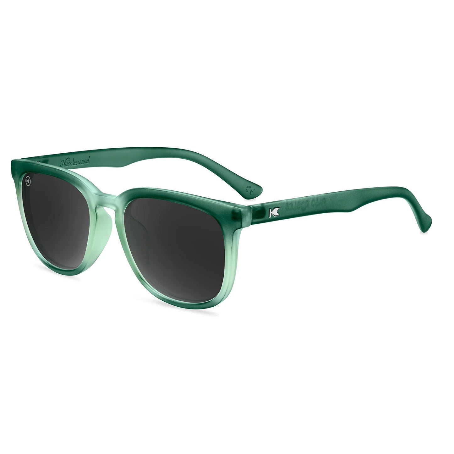 Green knockaround sunglasses with dark lenses on a white background