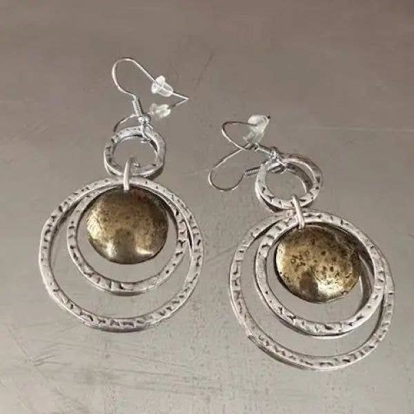 Pair of silver earrings with circular designs on a gray background