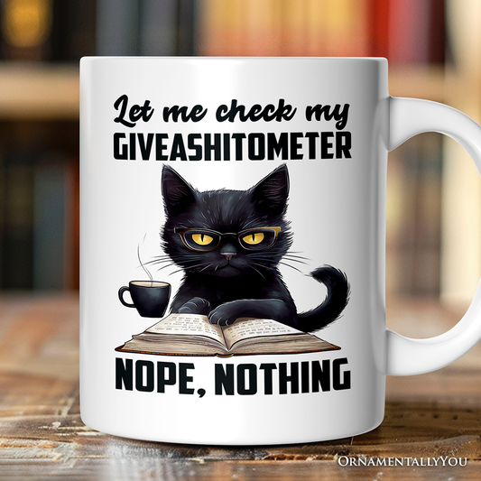 White mug with a black cat graphic and humorous text on a wooden surface.