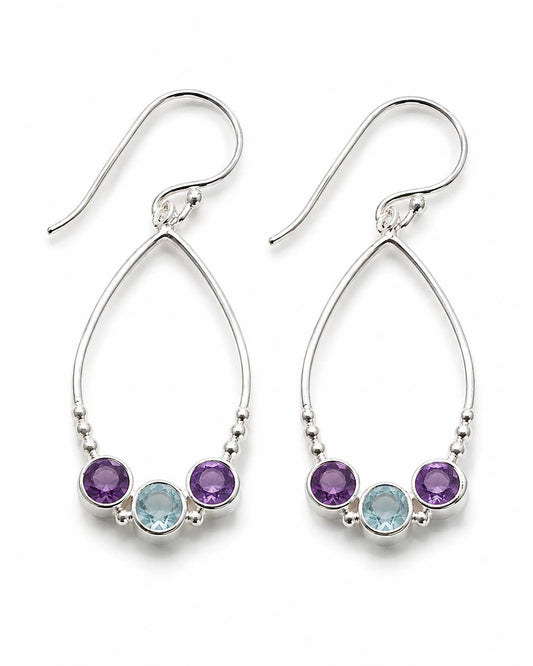 A pair of silver dangle earrings with three round gemstones in each earring: a purple stone, a light blue stone, and a smaller dark purple stone, set against a plain white background.