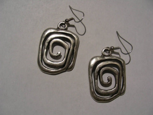 A pair of textured silver drop earrings with a spiral design, shown on a plain light gray background.