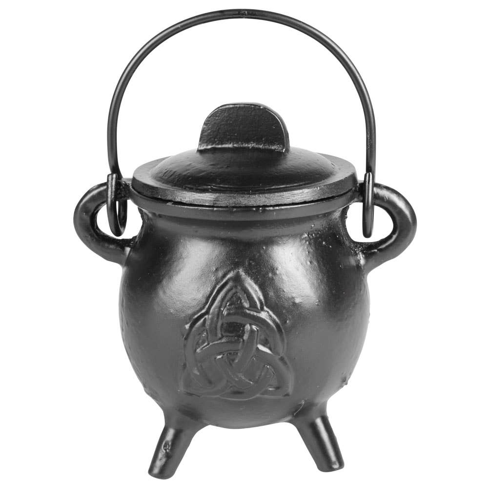 A black cast iron cauldron-shaped pot with a lid, triple feet, side handles, and a top handle loop, featuring an embossed Celtic triquetra symbol on the front, shown against a plain white background.